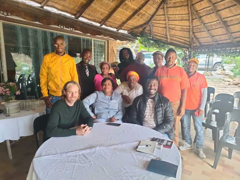 Image of Jean Cooper and Elvis Zondi meeting with community leaders at Ezenzeleni